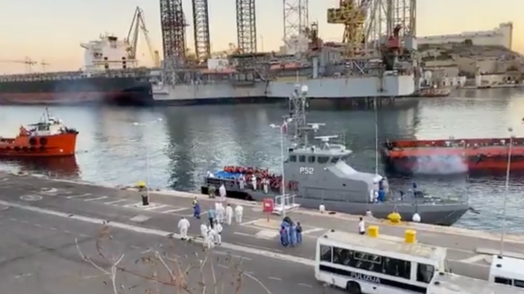 94 rescued migrants being swabbed one by one before disembarking in Isla and isolated moments later. 85 of this cohort eventually tested positive. Screenshot from a Facebook Live video by NET News