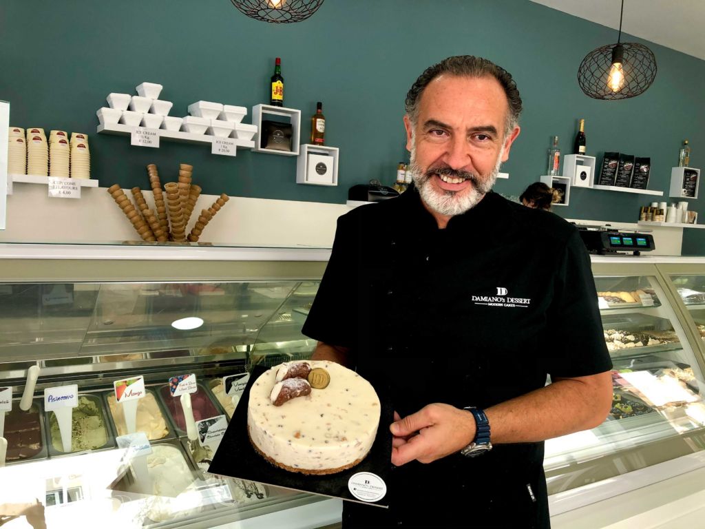 Owner Marco holding the cannoli cake