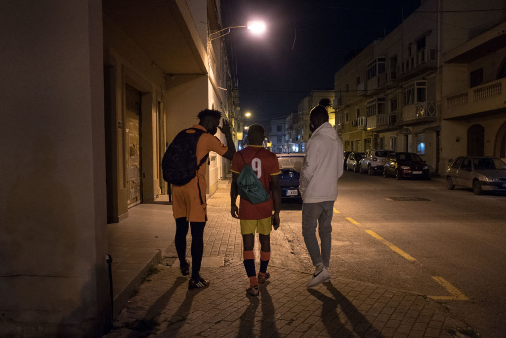 Abdul, Abdalla and Lamin walk home after playing a football game with friends