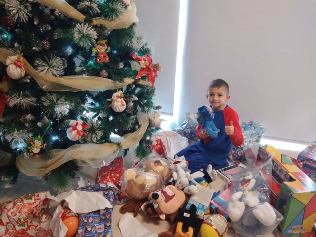 Kane Debattista poses with a mountain of Christmas presents